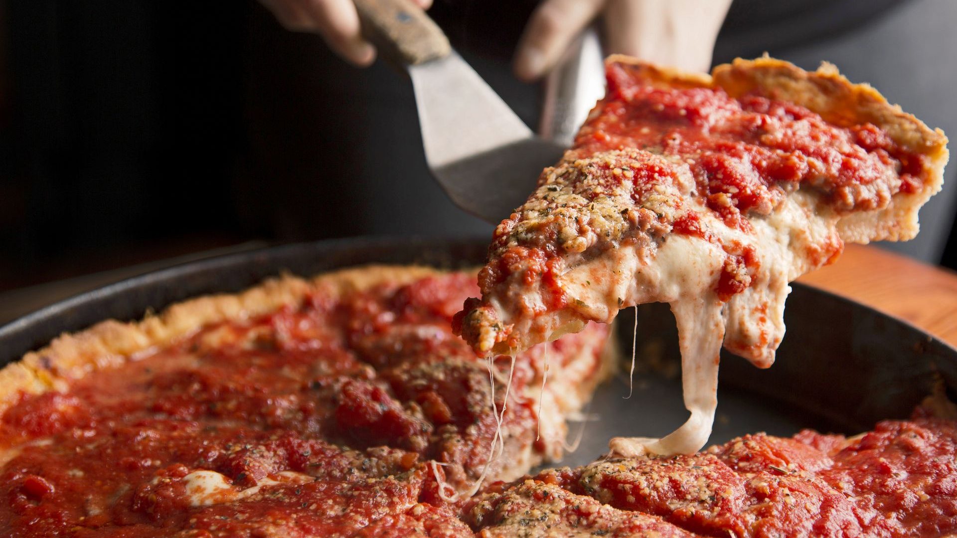 slice of deep-dish pizza being served at Lou Malnati's in Chicago Illinois