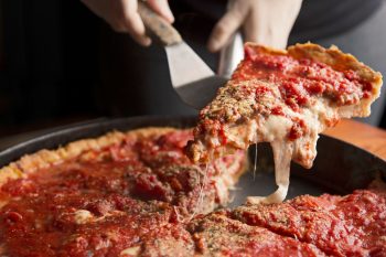 slice of deep-dish pizza being served at Lou Malnati's in Chicago Illinois