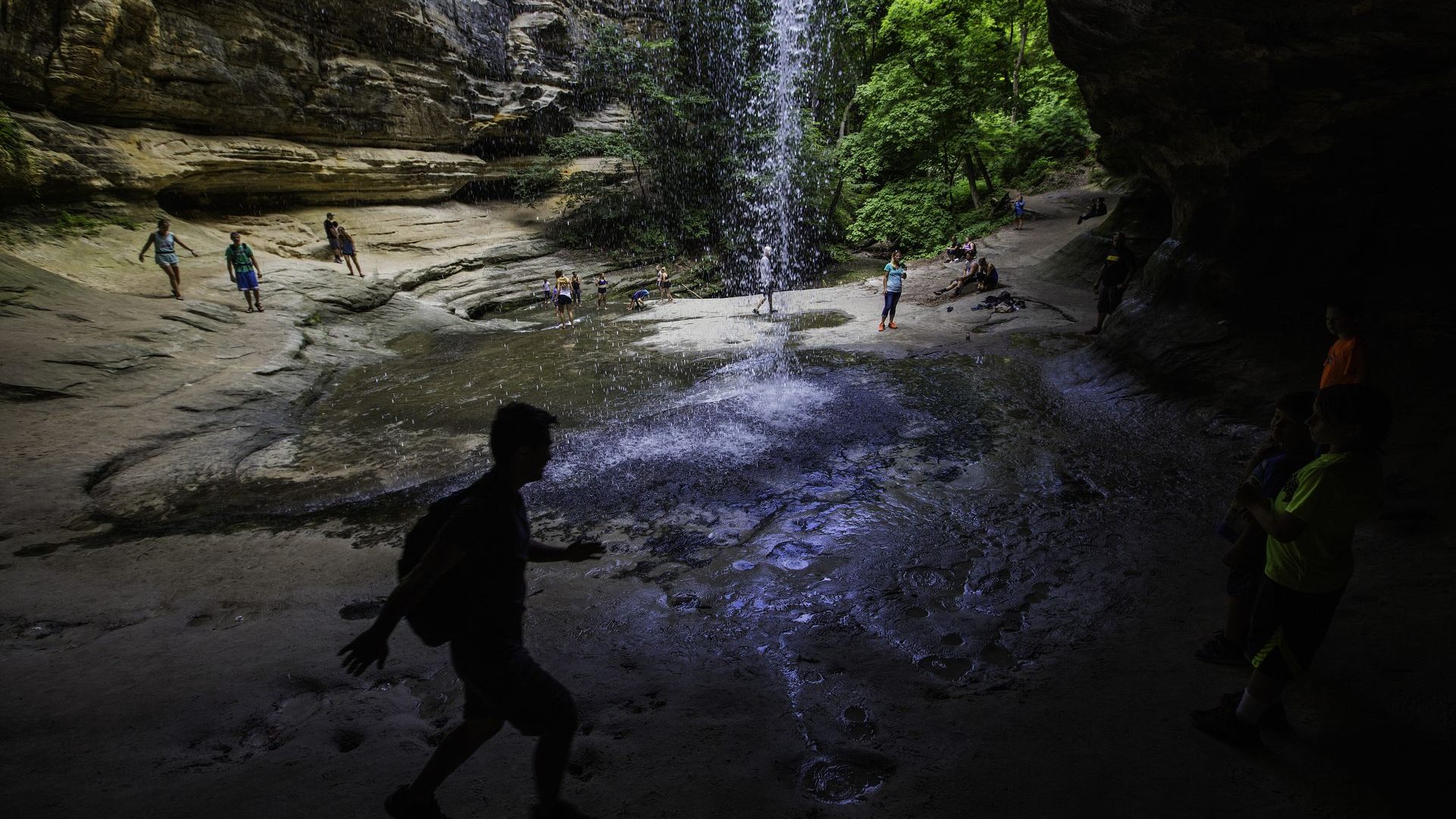 Hikers at a waterfall in a canyon at Starved Rock State Park in Illinois