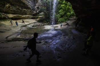Hikers at a waterfall in a canyon at Starved Rock State Park in Illinois