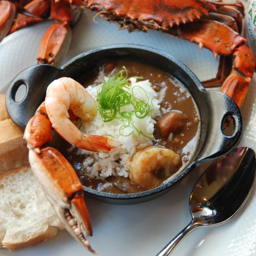Bowl of seafood gumbo with shrimp, crab and Tabasco sauce
